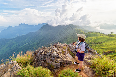 旅游风景优美的女游客山景点天空相机公园顶峰单反森林女士远足日落图片