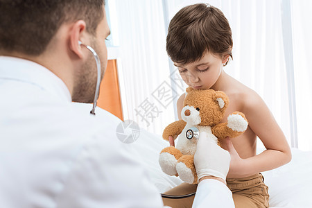 男医生 用听诊器检查小男孩抱着泰迪熊的情况男人从业者医院玩具卫生孩子儿科疾病临床医疗保险图片
