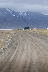 在贫瘠山脉下 蓝色海湾的美丽景色风景海滨场景峡湾岩石沙漠酒吧银行巡航旅行苔原图片