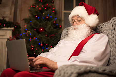 使用膝上型电脑的圣诞老人季节礼物笔记本新年假期喜悦灰色时候问候语水平图片