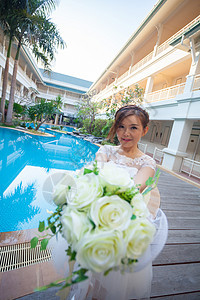 年轻可爱的亚洲女人 闻着白花香雏菊花束女孩女士女性喜悦游泳礼物水池微笑图片