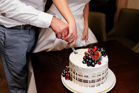 新婚夫妇切开用新鲜水果装饰的结婚蛋糕 新郎新娘切结婚蛋糕图片