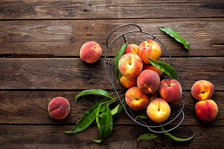 深木制生土背景 顶层风景的鲜桃果子和篮子叶子红色绿色乡村营养黄色油桃饮食水果食物桃子图片