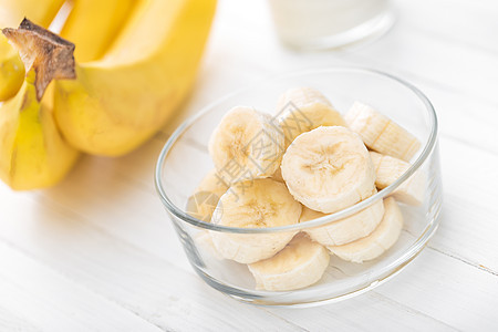 白色木制背景检查 健康饮食上的新鲜切片香蕉皮肤营养热带黄色小吃食物水果饮食图片