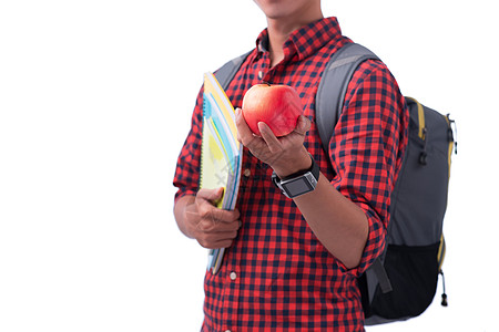 苹果园区手握着红苹果和书 在白色上被孤立微笑青少年教育男人成功背包食物学校男生大学背景