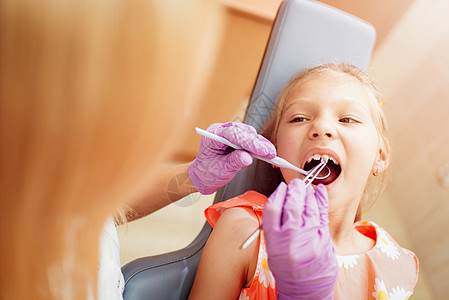 牙医时的小女孩微笑嘴巴手套设备孩子医生小姑娘选择性牙钻水平图片