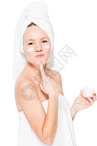 洗完澡后脸霜在白色背景上化妆的女孩图片