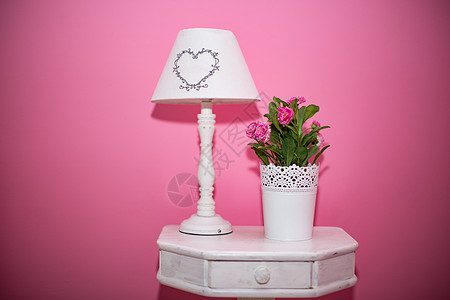 粉红色背景的桌灯和花束图片