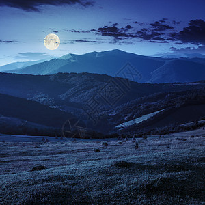 夜间在靠近村庄的山坡上作业国家草垛天空蓝色天气爬坡草地环境行星月亮图片