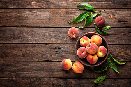 深黑木制生锈背景上有叶子的新鲜果桃营养绿色饮食油桃食物树叶红色市场桃子桌子图片