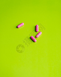 粉红色药丸和药物 在绿色的桌子和回声工作室医生药剂食物背景脂肪药品饮食开心果水果图片