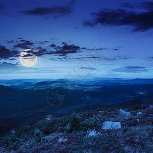 在山边的石头上 在夜间岩石风景旅行山脉爬坡蓝色地球月亮星星山坡图片