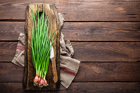木板上的绿洋葱或 新鲜的春铃洋葱末日乡村烹饪蔬菜叶子饮食美食厨房韭菜图片