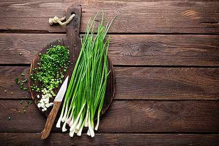 木板上的绿洋葱或 新鲜的春铃洋葱营养韭菜厨房乡村植物叶子食物蔬菜沙拉图片