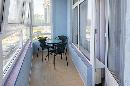 一座多层公寓大楼的公寓楼阳台上的一张桌子和三张椅子釉面住宅绝缘露台绿化咖啡玻璃窗娱乐地面天花板图片