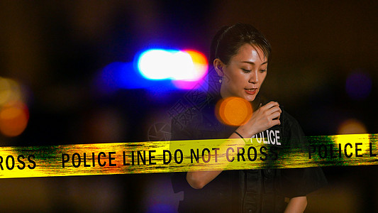 使用警察电台的亚裔美洲女女警察职业徽章收音机安全对讲机磁带场景执法情况犯罪图片