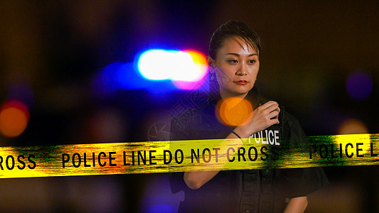 使用警察电台的亚裔美洲女女警察交通女警收音机回应者徽章女士执法磁带情况场景图片