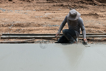 拼装地板男人把水泥砖压在地板上的胶水里男性手套材料瓦工安装装修内衬石头平铺工作背景