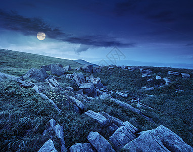 夜晚在山顶的石头上月亮草地岩石巨石爬坡地球山坡环境植物旅游图片