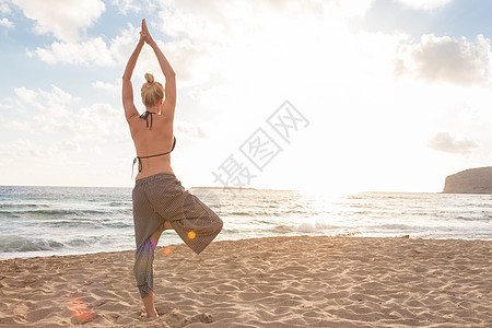 日落时在海边做瑜伽的女人平衡身体女士饮食女孩海滩支撑阳光天空海洋图片
