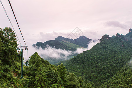 天门山zhan带绕风和弯曲路的电缆车高架运输公园爬坡道悬崖风景技术旅行森林石头图片