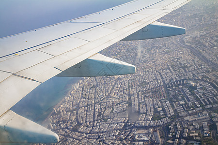 空中飞机机翼在天空和陆地上空与特拉维夫大楼图片