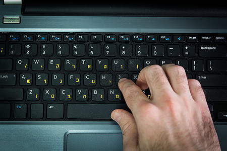 用希伯来语和英语字母在键盘打字的人工作按钮写作教育手指商务冲浪机动性技术商业图片