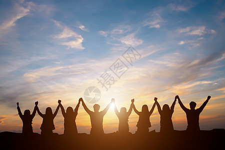欢乐的商务团队在日落中举高手图片