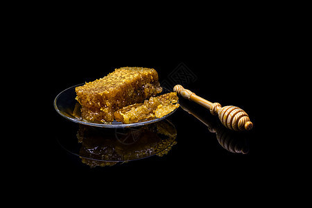 黑色背景中隔离的玻璃板上带有蜂窝的蜂蜜药品糖浆厨房健康液体食物蜜蜂产品早餐金子图片