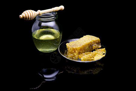 黑色背景中隔离的玻璃板上带有蜂窝的蜂蜜厨房甜点糖浆蜂蜡健康营养木头液体早餐食物图片