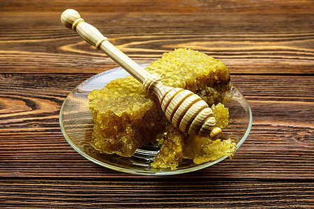 蜂蜜与蜂窝蜂蜜 在旧木制桌子上的玻璃盘子上健康金子蜜蜂蜂蜡勺子蜂窝糖浆药品早餐木头图片