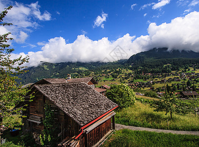 阿尔卑斯山风景如画的乡村山景的美丽全景明信片视图与传统的古老高山山区小屋和新鲜的绿色草地在阳光明媚的日子与蓝天和云彩在夏天农村公图片