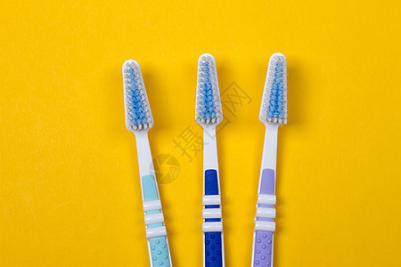 三个黄色背景的牙刷 W药品牙膏洗手间健康清洁工卫生浴室塑料牙医刷子图片