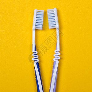 黄色背景的两根牙刷洗手间蓝色浴室治疗保健塑料呼吸工具刷子牙医图片