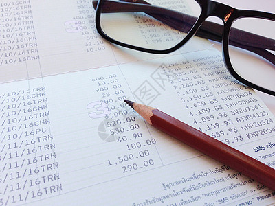 储蓄账户账簿或财务报表上的笔和眼镜;图片