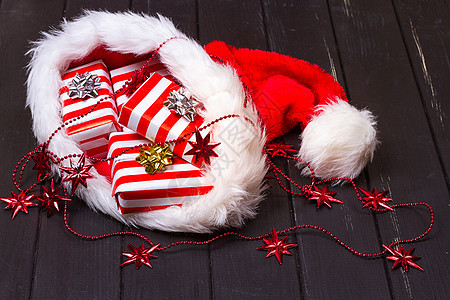 圣诞礼物戴圣诞圣诞老人帽子木头装饰季节性白色礼物红色木板桌子假期丝带图片