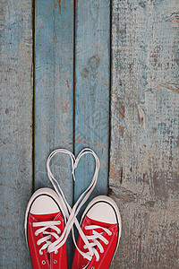 蓝木背景的一双红色复古运动鞋 蕾丝问候语学校夫妻朋友们鞋带海报假期木头木板鞋类图片