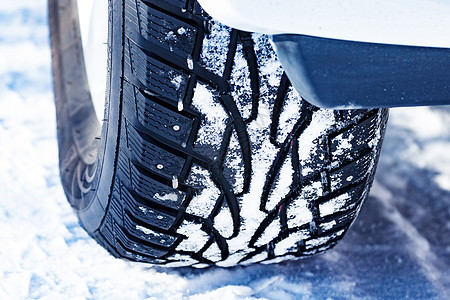 在 wi 覆盖着雪的汽车镶嵌轮胎的特写镜头螺柱车轮旅行天气安全运输橡皮街道车辆技术图片