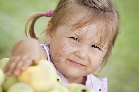 有苹果的小女孩孩子食物孩子们小吃乐趣裙子水果绿色草地童年图片