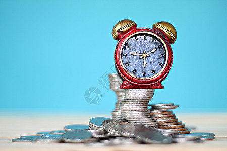 桌面桌上的微型时钟和硬币堆叠手表市场投资薪水小时基金收益退休经济财富图片