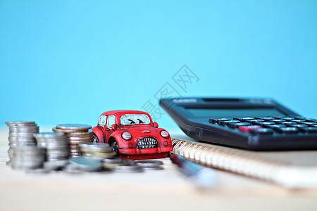 办公室桌桌桌上的微型汽车模型 硬币堆 计算器和笔记本纸图片
