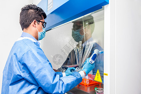 年轻的科学家 在安全的Laminar空气流库工作蓝色男性内阁烧瓶液体男人架子实验室遗传学流动图片