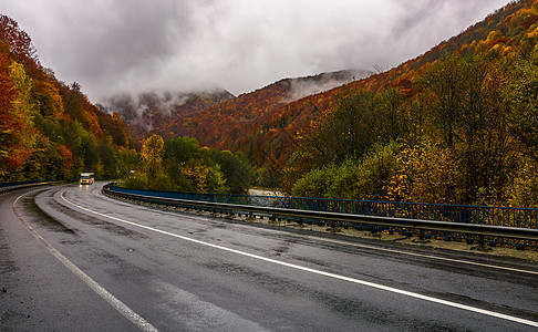 秋天雨季穿过山丘的曲线公路图片