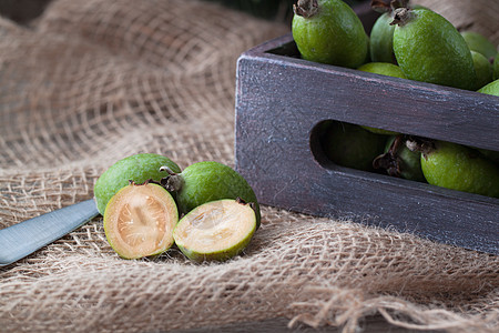 冬季圣诞礼物 Feijoa切碎了生锈背景的切片玻璃味道枞树情调异国芳香水果勺子亚麻美食图片