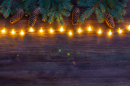 圣诞闪亮的Garland 树枝和圆锥子在木本底图片