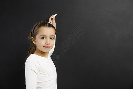 女孩在黑板上写字微笑学校孩子们绘画写作女性粉笔学习教育童年图片