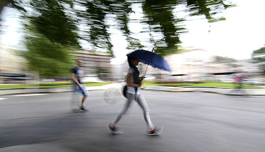 带着雨伞的人在城里走来走去高清图片