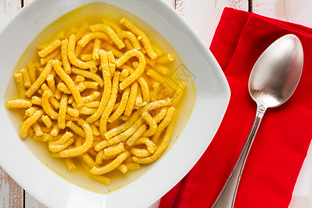 意大利薄汤的意大利皮卡图利盘子白色午餐黄色木头餐巾乡村食物勺子红色图片