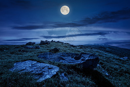 夜间在草地山坡上形成岩石图片