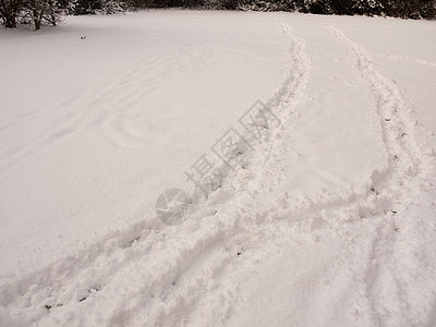 覆盖在雪中的字段中 有两条足迹穿透其风景文字u图片